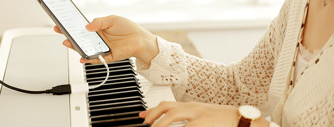 Girl using her mobile device with her Korg Digital Piano